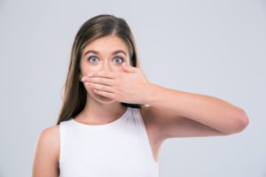 Female teenager covering her mouth