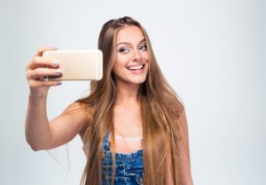 Cheerful woman making selfie photo on smartphone