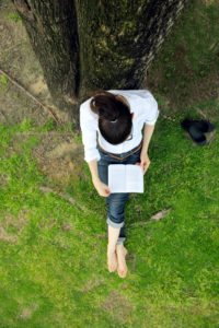 Young woman reading a book in the park